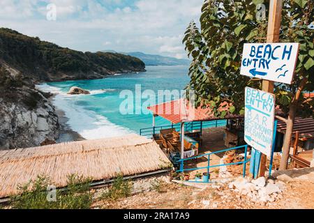 a hand painted sign indicates the entrance Pulëbardha Beach in Ksamil, Albania Stock Photo