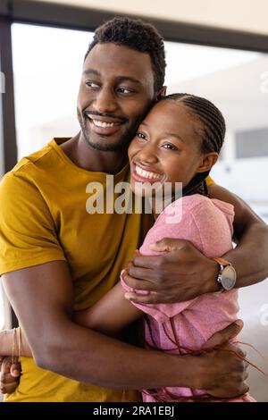 Happy african american couple hugging in living room Stock Photo