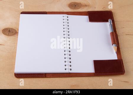 Blank scratchpad in leather cover with graphite pencil lie on wooden desk Stock Photo