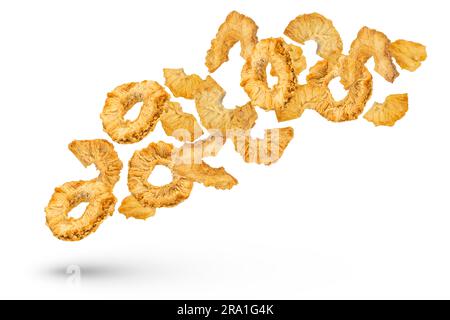 Falling slices of dried pineapple on a white isolated background. Dried pineapple rings of different cuts scatter in different directions. High Stock Photo