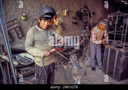Peru, in a small metal factory in Sicuani - near Cusco. Two workers are welding. Stock Photo
