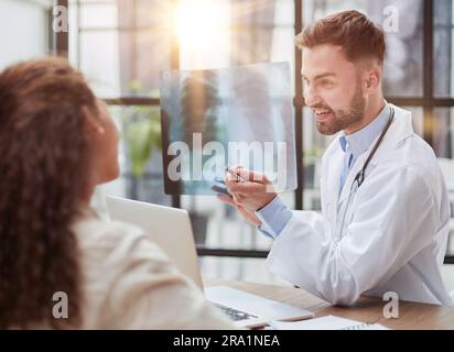 Concentrated male doctor looking at x-ray picture of spine Stock Photo