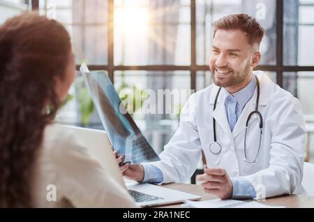 Concentrated male doctor looking at x-ray picture of spine Stock Photo