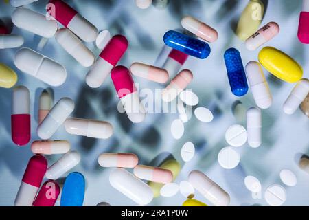 Tablets and capsules placed on a two level glass top creates effect of suspension in air, creative concept of scientific research, new drugs. Stock Photo