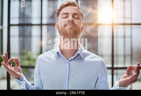 Young businessman relaxing while standing in the office Stock Photo