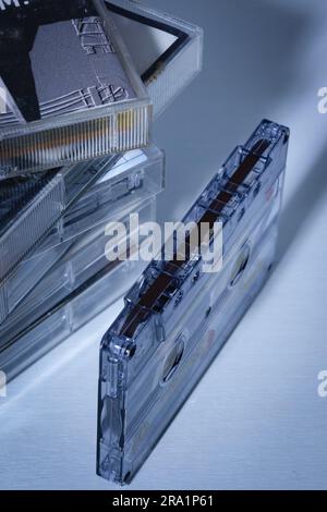 Partial view of a stack of stacked audio cassettes and one audio cassette in the foreground in the center of the frame. Stock Photo