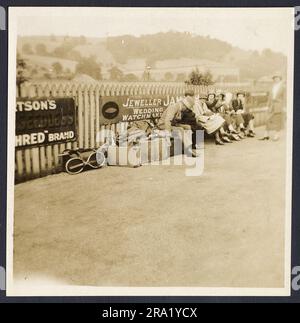 Two snapshot views of Butterley, an old crowded railway station platform in the 1920s, showing people waiting to traval to a tennis match. Advertising signs, fashion, also shows the photographer with his tripod mounted camera.  Very atmospheric. Stock Photo