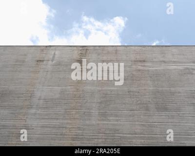 grey concrete wall over blue sky useful as a background Stock Photo