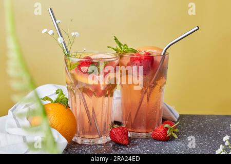 Aesthetic refreshing cocktails with citrus fruits and strawberries. Vitaminized summer detox water. Low-alcohol drinks, decorated with gypsophila. Stock Photo