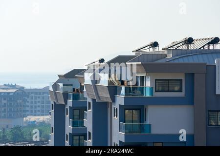 New modern apartment building. Details of modern urban architecture. A building with solar water heaters installed on the roof. Stock Photo