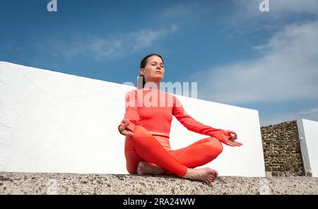 mid adult woman meditating and practicing yoga outside in the summer sun, healthy living concept. Stock Photo