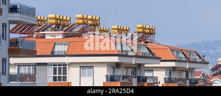 New residential building with solar water heaters on the roof. Urban architecture. Stock Photo