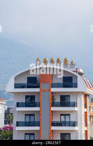 New residential building with solar water heaters on the roof. Urban architecture. Stock Photo