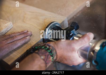 top view of a craftsman's hands at work with the router Stock Photo