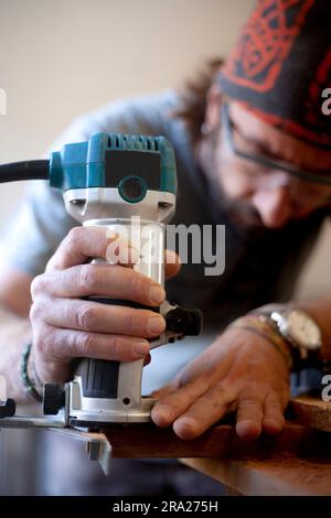 Woodworker using a router for woodworking. Stock Photo