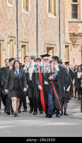 Led by staff, students from Magdalene College, University of Cambridge, England, process past St John's College to Senate House for their graduation award ceremony on Friday 30 June 2023. Stock Photo