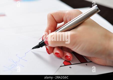 hand with a fountain pen on paper signs Stock Photo