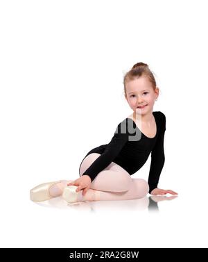 Little ballerina in pointe sitting on floor Stock Photo