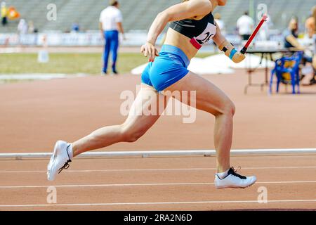 woman para athlete on prosthetic left hand running track stadium, summer para athletics championships Stock Photo
