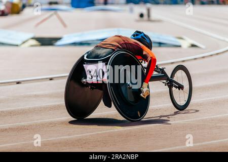 female athlete in wheelchair racing track stadium in para athletics competition, summer sports games Stock Photo