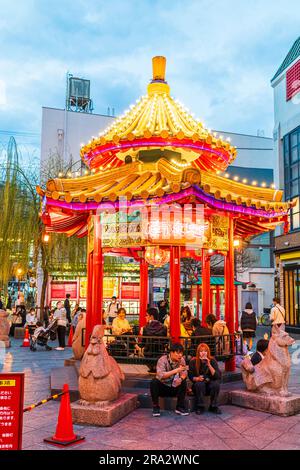 The popular Azumaya pavilion in Nankinmachi Square in Chinatown, Kobe. Evening, with people sitting inside and outside while eating Chinese food. Stock Photo