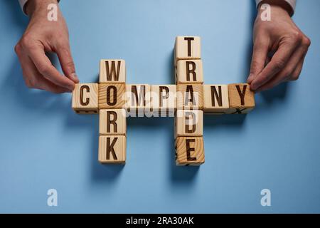 The words company work trade on wooden cubes on a blue background. Stock Photo