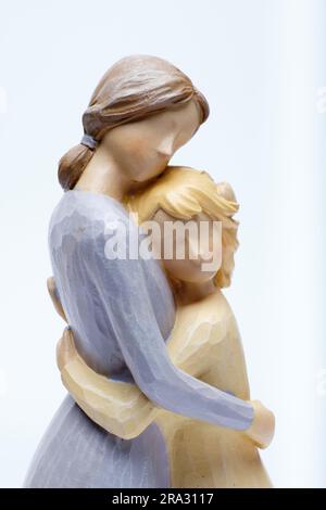 Christian themed ceramic ornament close-up of a mother hugging her daughter against a white background. Stock Photo