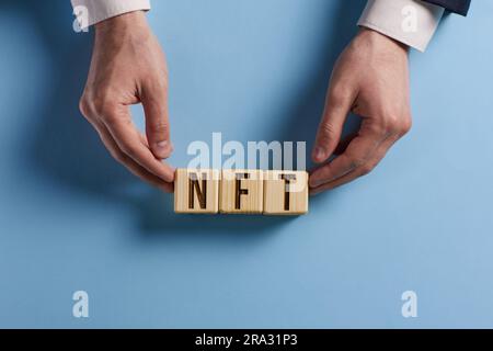 Wooden cubes with word NFT. buying and sale type of cryptographic nft tokens. Stock Photo