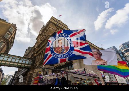 Charles III Coronation week in London. King Charles III, Queen Elizabeth II, union jack flags, UK flags wave at a souvenir shop in Westminster. Stock Photo