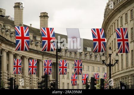 UK Union Jack flags and a King Charles III Coronation flag decorate Regent Street in London. The British flags are raised for celebrations, Coronation Stock Photo