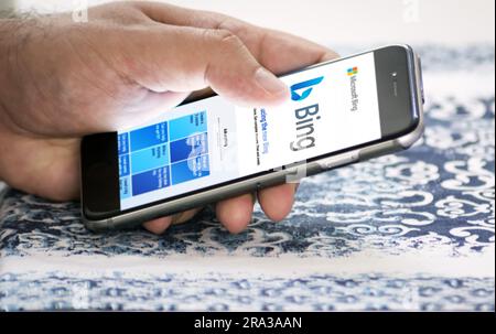 Redmond, US, Feb 28 2023: A hand holding a phone with the Microsoft Bing website on the screen. Bing is a search engine recently integrated with AI ch Stock Photo