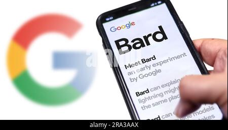 San Francisco US, May 12 2023: A hand holding a phone with the Google Bard website on the screen. White background with blurred Google logo. Bard is G Stock Photo