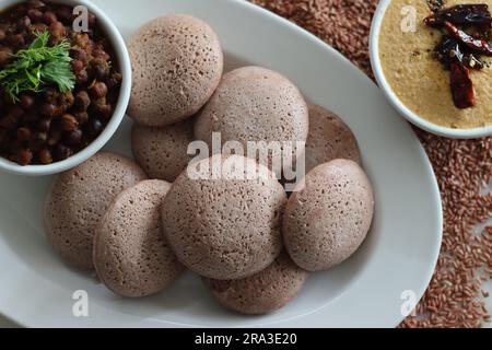 Navara rice idly served black chickpea curry. Steamed savoury rice cake made by a batter of fermented de husked black lentils and navara rice. Navara Stock Photo