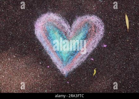 Heart sign drawn with pastel colors chalk on playground rubber floor Stock Photo