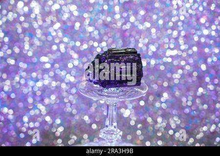 Tourmaline in the studio against a blue background on a crystal glass Stock Photo