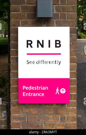 sign at the pedesestrian entrance to the charity RNIB royal national institute for blind people with phrase see differently, Stock Photo
