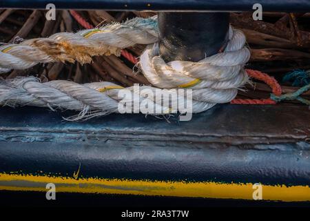 Photograph of old white rope wrapped around a steel pipe on a fishing boat on King Island in the Bass Strait of Tasmania in Australia Stock Photo