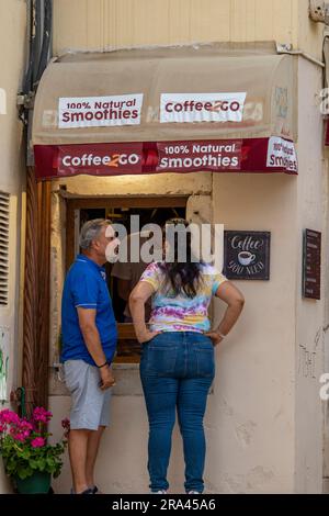 man and woman couple buying coffee from a street kiosk. Stock Photo