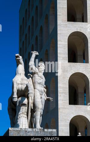 Equestrian sculpture with Palace of Italian Civilization (Palazzo della Civilta Italiana) behind, EUR district, Rome, Lazio, Italy Stock Photo