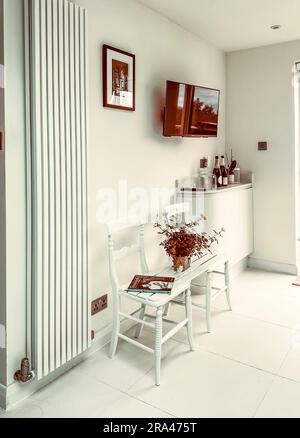 A bench seat made by joining two chairs in a modern, contemporary white kitchen. (I have no release for the book in the picture) Stock Photo