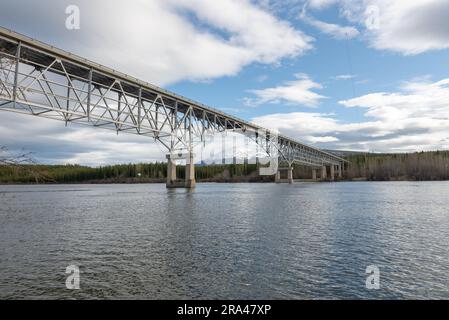 Johnsons Crossing, Teslin River steel Bridge on the Alaska Highway during spring summer time with cloudy, sky day and magnificent, huge structure Stock Photo