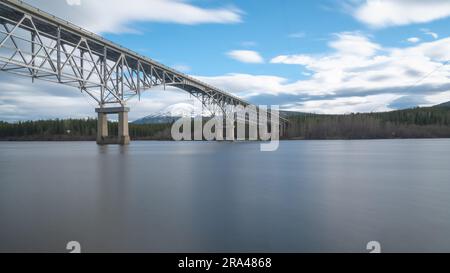 Johnsons Crossing, Teslin River steel Bridge on the Alaska Highway during spring summer time with cloudy, sky day and magnificent, huge structure Stock Photo