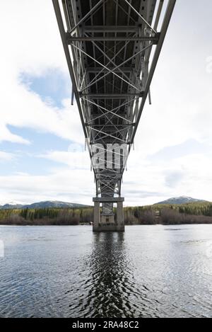 Johnsons Crossing, Teslin River steel Bridge on the Alaska Highway during spring summer time with cloudy, sky day and magnificent, huge structure Stock Photo