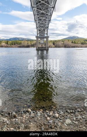 Johnsons Crossing, Teslin River steel Bridge on the Alaska Highway during spring summer time with cloudy, sky day and magnificent, huge structure Stock Photo