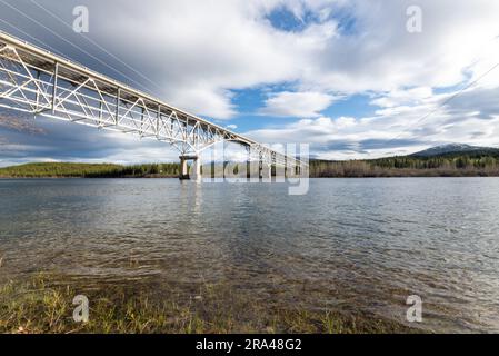 Johnsons Crossing, Teslin River steel Bridge on the Alaska Highway during spring summer time with cloudy, sky day and magnificent, huge structure Stock Photo