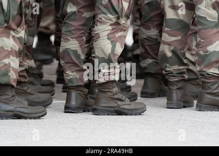 Soldiers in a relaxed position during the ceremony. Military unit. Military camouflage outfit. Soldier shoes. Stock Photo