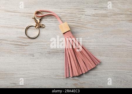 Pink leather keychain on light wooden background, top view Stock Photo