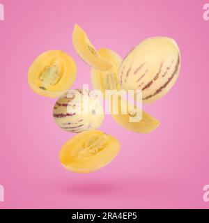 Fresh ripe pepino melons falling on bright pink background Stock Photo