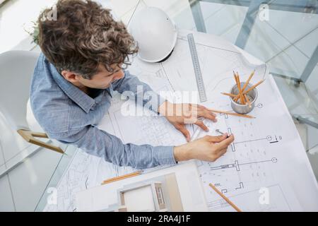 Young handsome architect engineer working on design plan Stock Photo