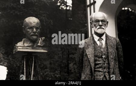 1931 , july , Vienna , AUSTRIA : The austrian father of psychoanalysis SIGMUND FREUD ( Freiberg 1856 - London 1939 ) . In this photo in Vienna , in a garden in Pötzleinsdorf ,  in front of his bust portrait by croatian sculptor OSCAR NEMON ( 1906 - 1985 ), sculpted in occasion of his 75 th birthday . This same photo was pubblished in cover of illustrated french magazine VU , 20 july 1932 . Sigmund Freud escape from austrian Nazi in 4 june 1938 , directed to London , via Ostenda ( Holland ) harbor . Unknown photographer ( possible by photographer and yournalist Nicolas Bandy aka Nicolas Neumann Stock Photo